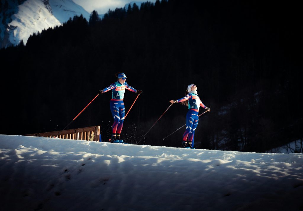 Two skiers performing on a snowy slope in Le Grand-Bornand, France, showcasing winter sports action.